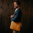 Man carrying the Tan Leather Messenger Bag