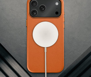 MagSafe charger attached to the Slimline Orange Leather Bumper Case for iPhone 17 Pro Max