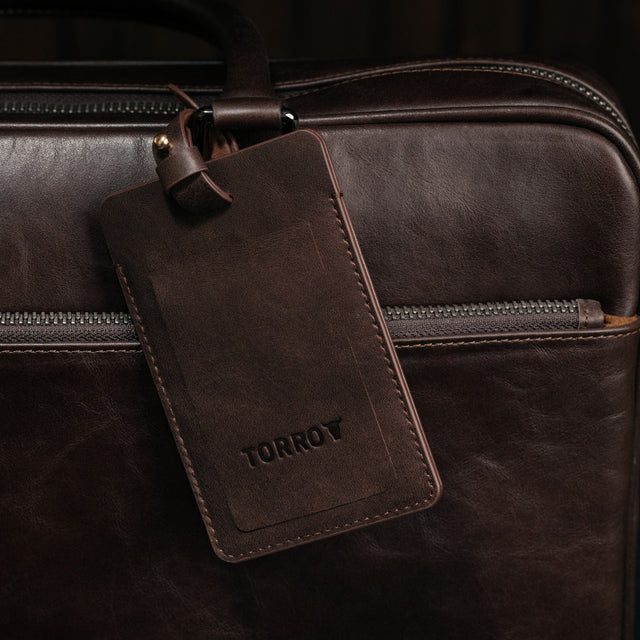 Dark Brown Leather Luggage Tag attached to luggage